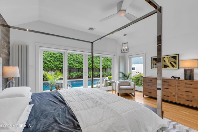 bedroom featuring lofted ceiling, access to exterior, and light wood-type flooring