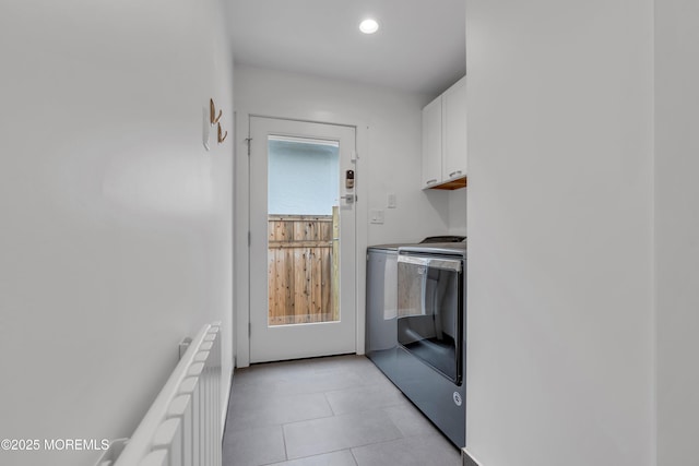laundry room with washer and dryer, cabinet space, radiator, light tile patterned floors, and recessed lighting
