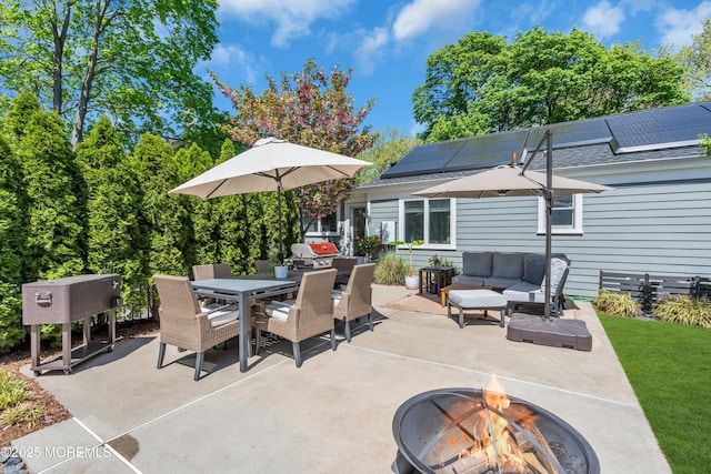 view of patio with outdoor dining space and an outdoor living space with a fire pit