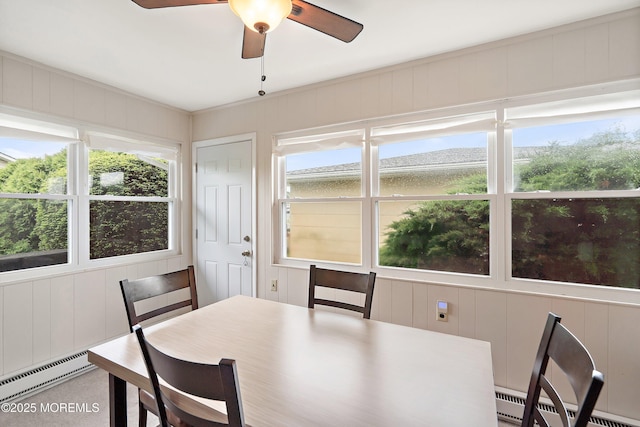 dining room with baseboard heating, healthy amount of natural light, and a decorative wall
