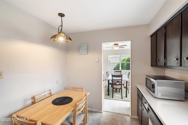 dining space with baseboards, light wood-style floors, and ceiling fan