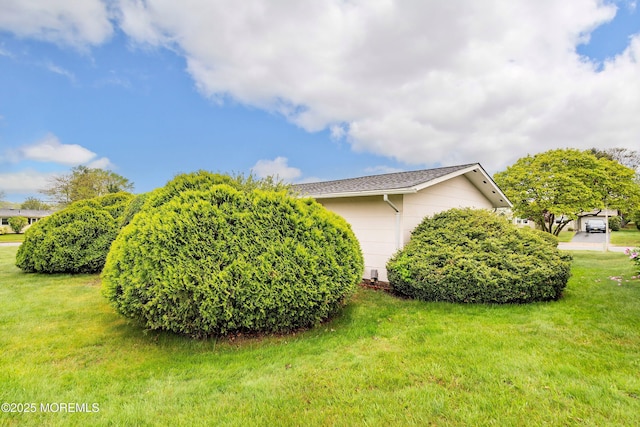 view of side of property with an attached garage and a yard