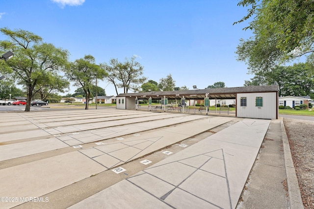 view of home's community with uncovered parking and shuffleboard