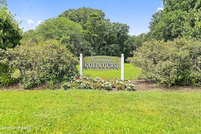 community / neighborhood sign with a yard