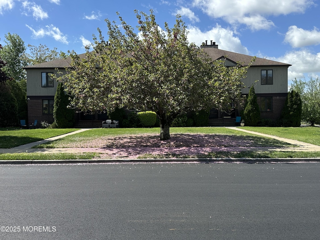 108 Neptune Ave Unit C, Deal, NJ 07723 - obstructed view of property featuring brick siding and a front lawn