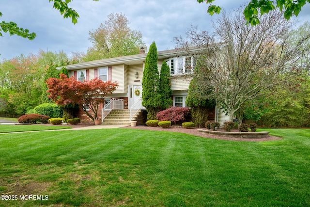 bi-level home featuring a front lawn and a chimney