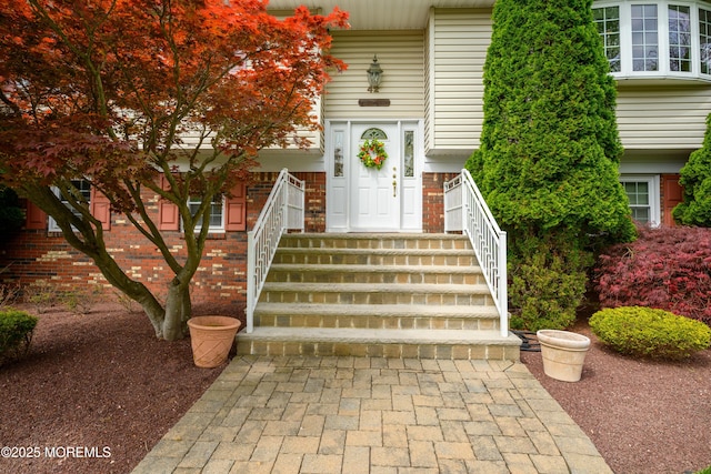entrance to property featuring brick siding