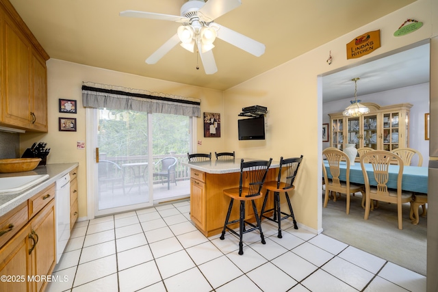 dining area with a ceiling fan, light tile patterned floors, baseboards, and light carpet