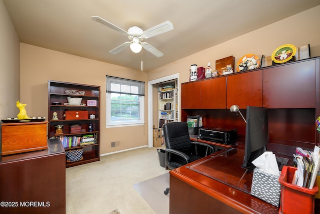 home office featuring ceiling fan, light colored carpet, and baseboards