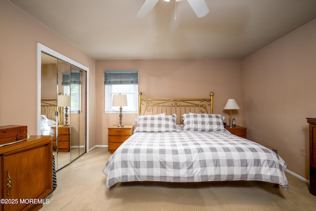 bedroom featuring light carpet, baseboards, a closet, and ceiling fan