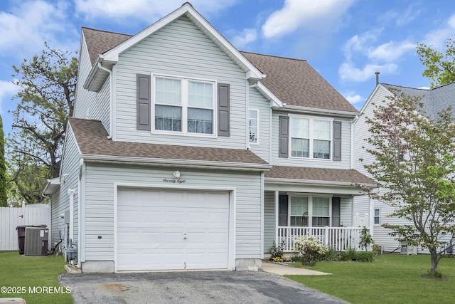 view of front of house featuring a porch, a garage, a front yard, and roof with shingles