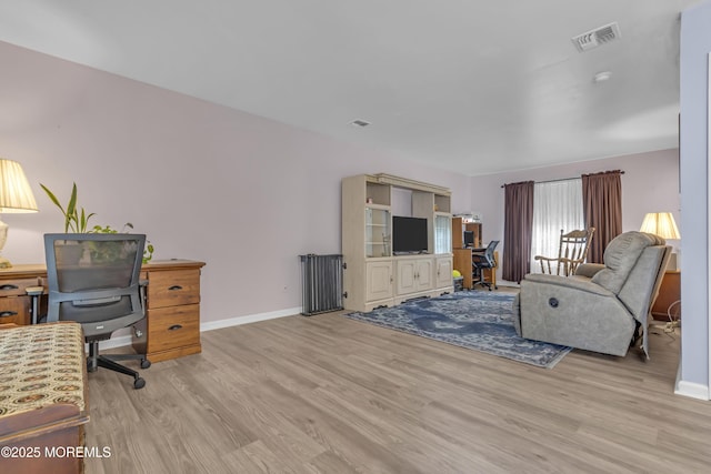 living room with an office area, wood finished floors, and baseboards
