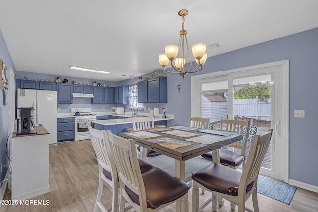 dining area with a chandelier, plenty of natural light, light wood-style floors, and baseboards