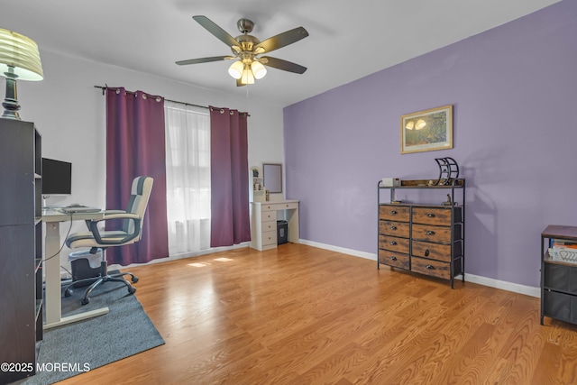 home office with a ceiling fan, wood finished floors, and baseboards