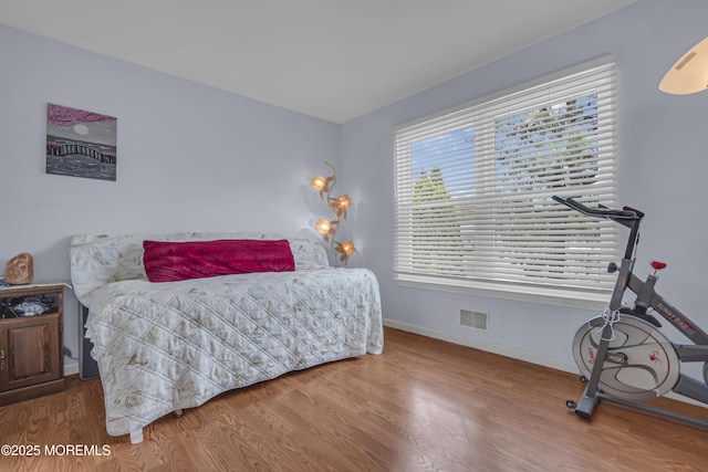 bedroom with wood finished floors and baseboards