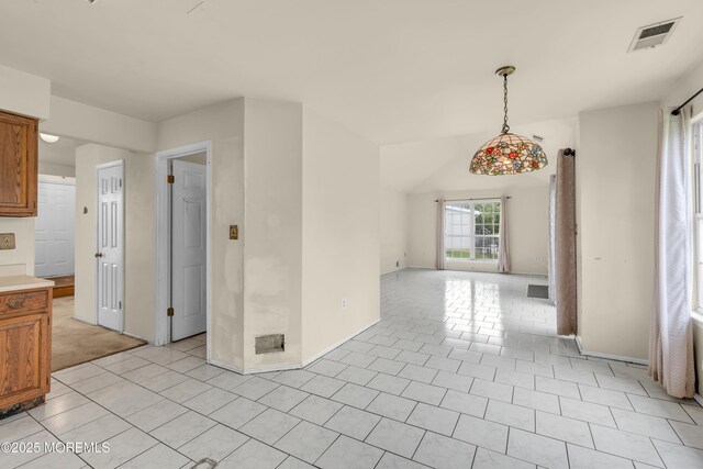 unfurnished dining area with baseboards and light tile patterned floors
