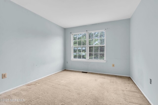 empty room featuring carpet flooring and baseboards