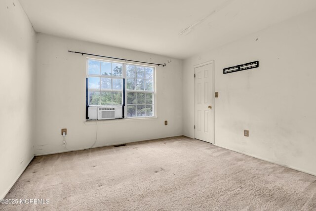 unfurnished room featuring carpet and cooling unit