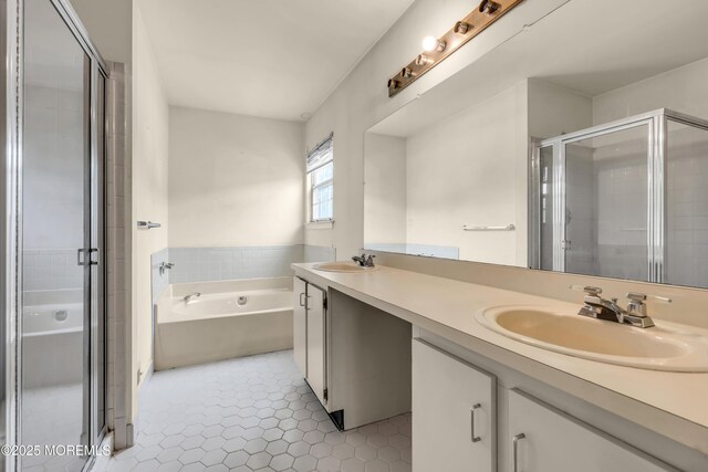bathroom featuring a stall shower, a bath, double vanity, and tile patterned flooring