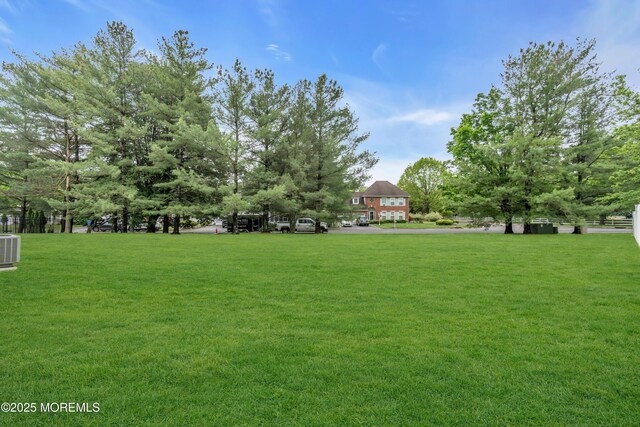 view of grassy yard with central AC unit