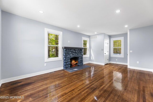 unfurnished living room featuring a fireplace, wood finished floors, baseboards, and recessed lighting