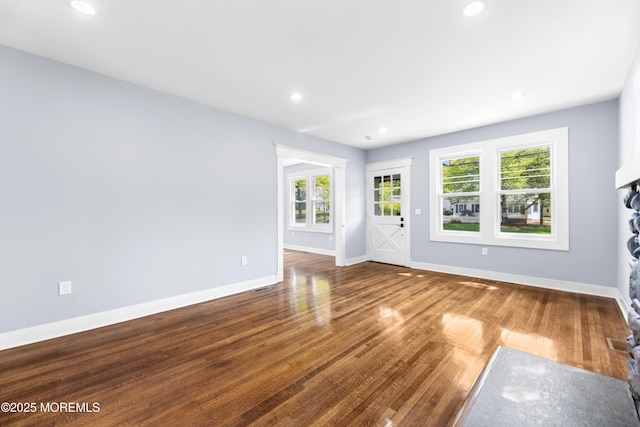 unfurnished living room featuring wood finished floors, baseboards, and recessed lighting