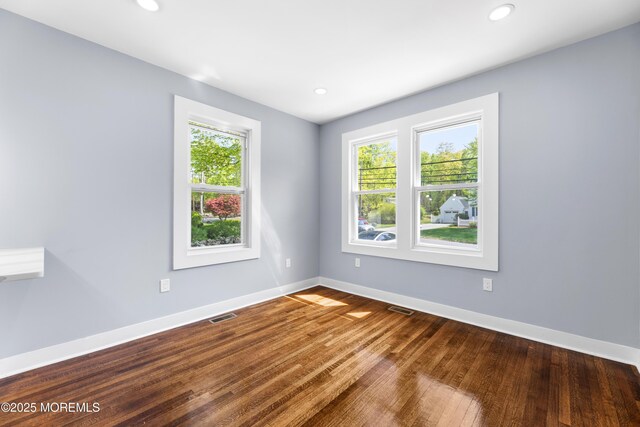 unfurnished room featuring healthy amount of natural light, baseboards, wood finished floors, and recessed lighting