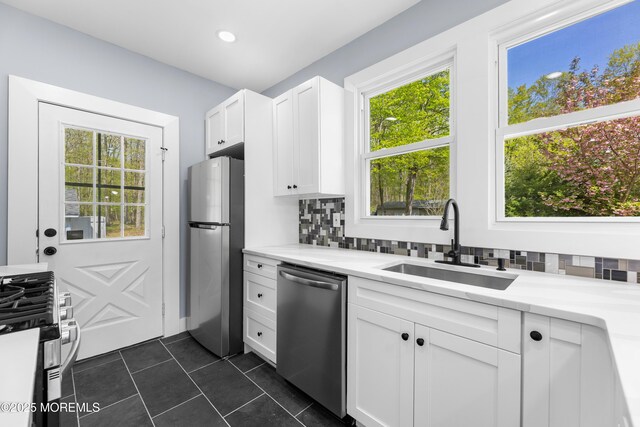 kitchen with stainless steel appliances, a sink, decorative backsplash, healthy amount of natural light, and recessed lighting