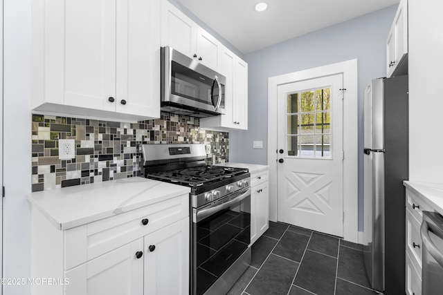 kitchen with appliances with stainless steel finishes, backsplash, white cabinets, light stone counters, and recessed lighting