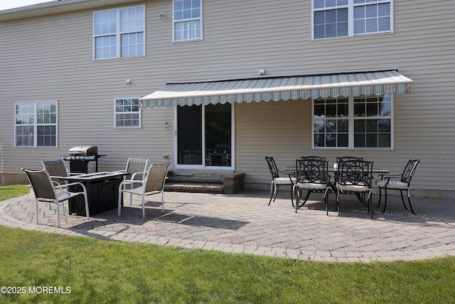 back of property with a patio area, outdoor dining area, and entry steps