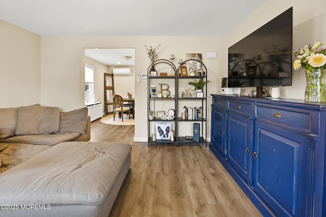 living area with wood finished floors and a wall unit AC