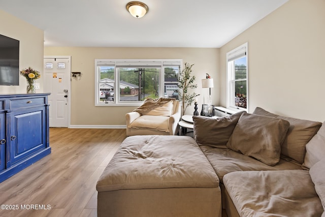 living area featuring light wood finished floors and baseboards