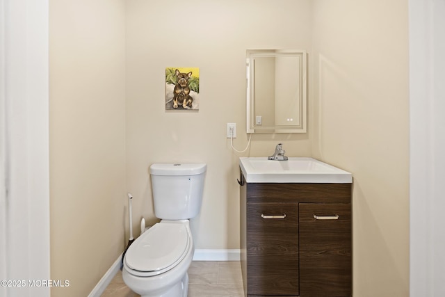 bathroom with baseboards, vanity, and toilet