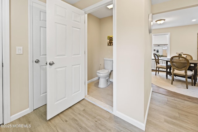 bathroom featuring toilet, baseboards, and wood finished floors