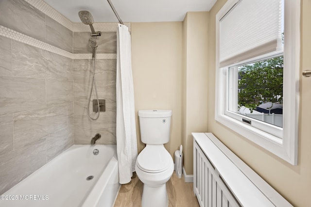 bathroom with toilet, radiator, baseboards, and shower / tub combo