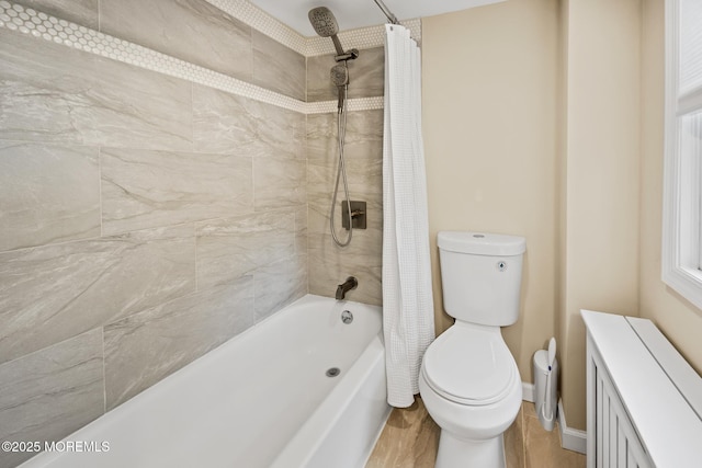 bathroom featuring toilet, radiator, wood finished floors, and shower / bath combination with curtain