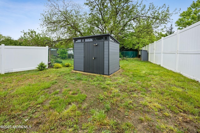 view of yard featuring a fenced backyard, an outdoor structure, and a shed