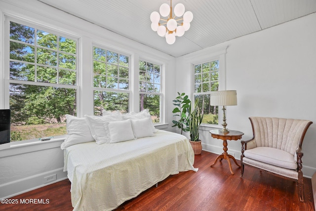 bedroom featuring baseboards, a notable chandelier, and wood finished floors