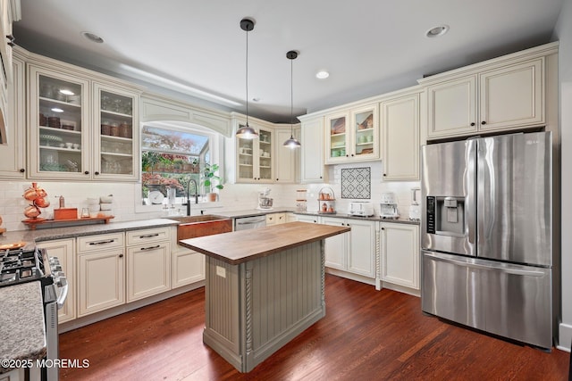 kitchen featuring dark wood-style flooring, wooden counters, appliances with stainless steel finishes, and decorative backsplash