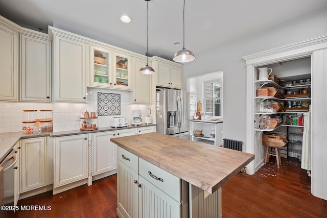 kitchen featuring dark wood finished floors, tasteful backsplash, butcher block counters, and stainless steel refrigerator with ice dispenser