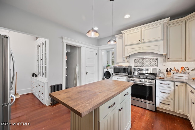 kitchen with dark wood-style flooring, appliances with stainless steel finishes, wooden counters, and cream cabinetry