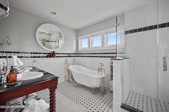 full bath featuring a wainscoted wall, a freestanding bath, a shower stall, and vanity