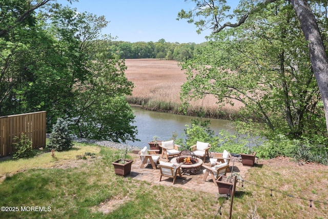 view of yard with an outdoor fire pit, a patio, and a water view