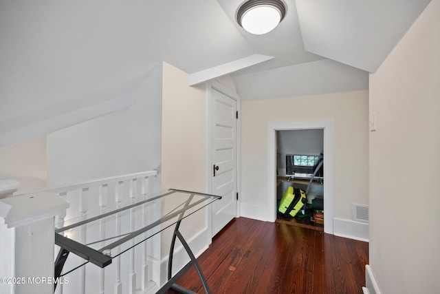 hallway with visible vents, wood finished floors, and baseboards