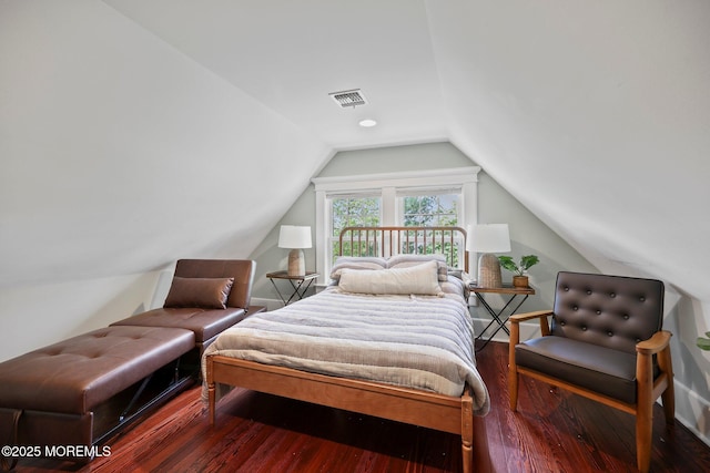 bedroom with visible vents, lofted ceiling, and hardwood / wood-style flooring