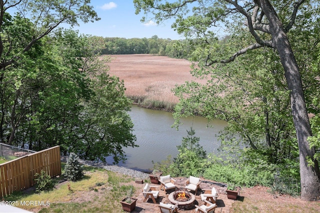 view of water feature featuring an outdoor fire pit and fence