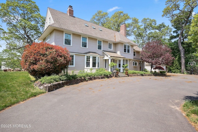colonial house with roof with shingles and a chimney