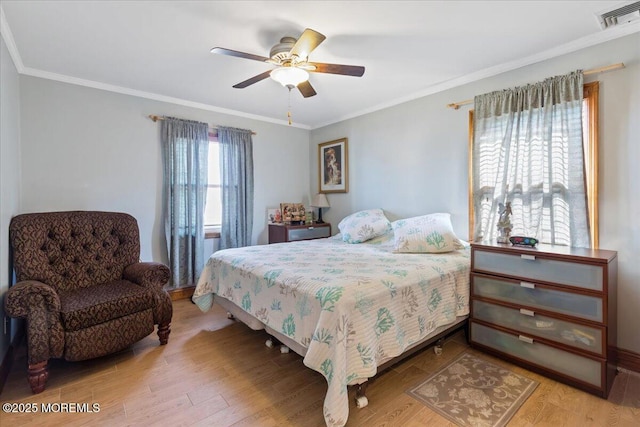 bedroom featuring wood finished floors, crown molding, and a ceiling fan