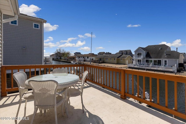 view of patio with a residential view, a water view, and outdoor dining area