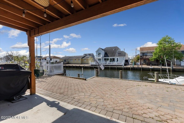 view of patio / terrace with a water view, a dock, a residential view, and area for grilling